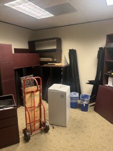 An office room cluttered with old furniture, filing cabinets, and equipment, awaiting removal by Prestige Junk Removal & Hauling in Detroit, MI