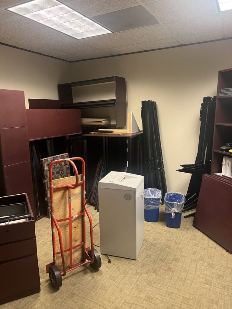 An office room cluttered with old furniture, filing cabinets, and equipment, awaiting removal by Prestige Junk Removal & Hauling in Detroit, MI