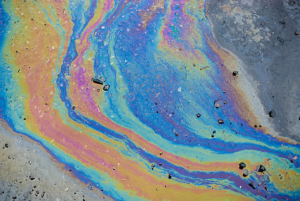A vibrant oil spill on asphalt requiring cleanup by Environmental & Hazmat Services in Ashford, AL.