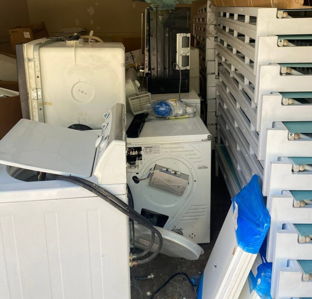 Old appliances and wooden pallets in a room, ready for junk removal by Veterans Easy Trash: Atlanta in Atlanta, GA.