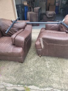 Two old, worn-out armchairs placed outside for junk removal by Dump My Junk LLC Demolition & Dumpster Rental in Tampa, FL.