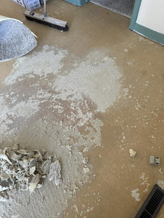 Close-up of old carpet adhesive and debris being removed from a floor by Wheeler's Handyman Services in Vermillion, SD