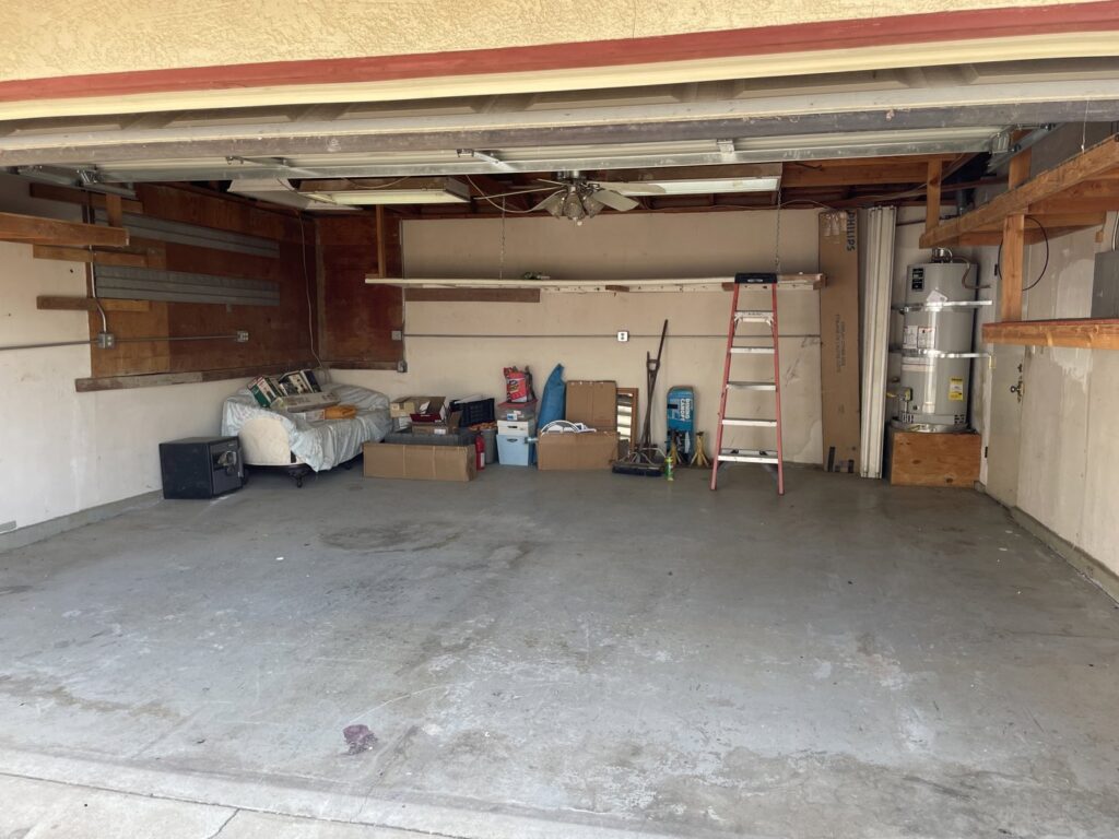 Old chairs, a ping-pong table box, and other items piled up against a house, ready for junk removal by Area 661 Hauling in Bakersfield, CA.