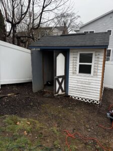An old, dilapidated shed in a backyard, indicating a shed removal or demolition service by Junkin Irishman in Wayne, NJ.