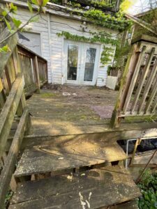 An old, dilapidated wooden deck covered in moss, showing a need for repair or replacement by The Golden Touch handyman services in Huntington, WV.