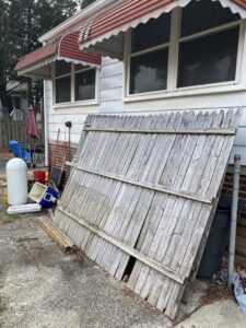 An old wooden fence panel and other debris awaiting removal by Navarro Demo LLC in Rockville, MD