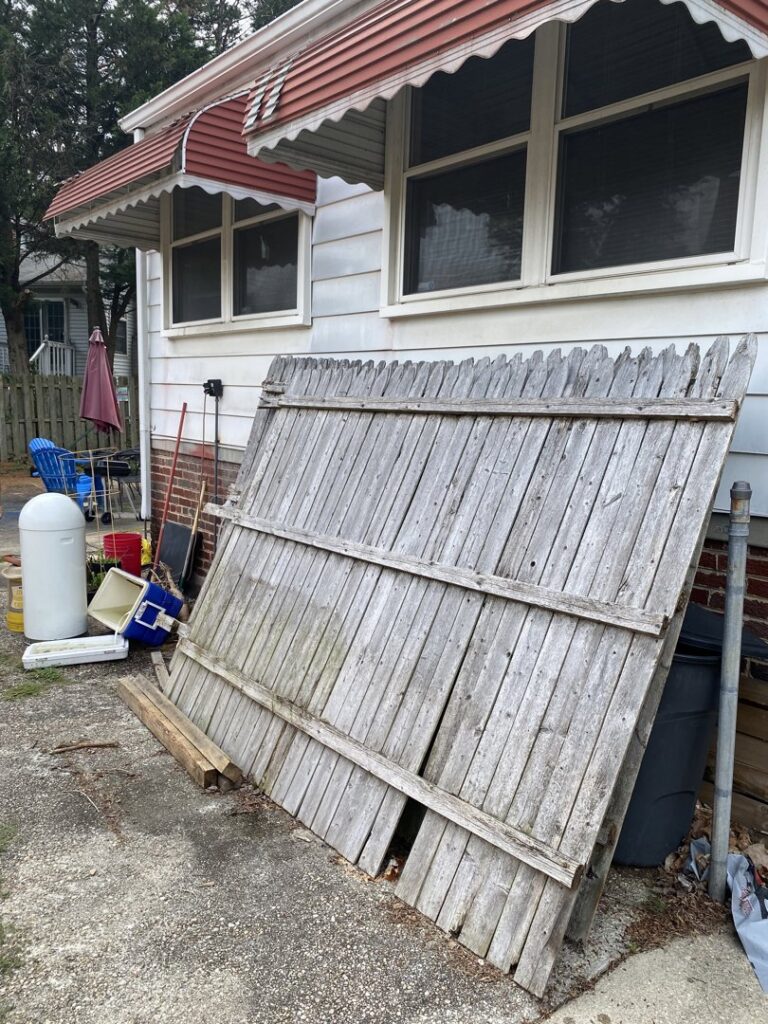 An old wooden fence panel and other debris awaiting removal by Navarro Demo LLC in Rockville, MD