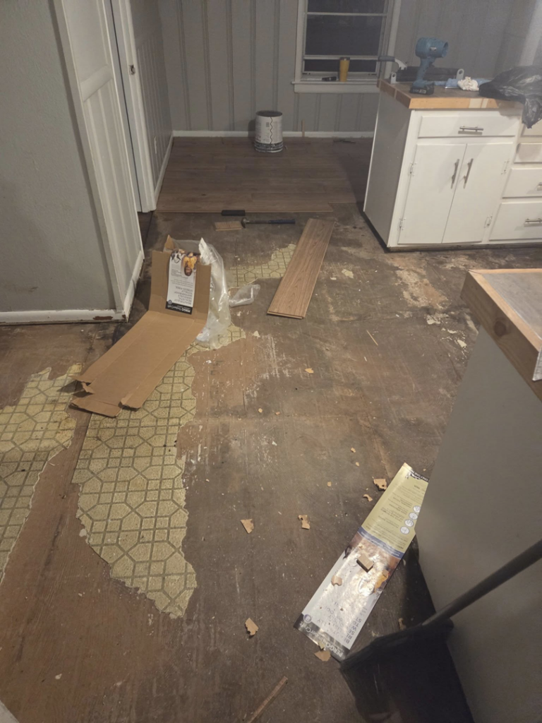 Old flooring removed and new planks ready for installation, showcasing flooring services by Joel's flooring & Handyman services in Roy, UT.