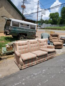 Old furniture and a truck bed camper shell placed roadside for Sonny Day Junk Removal in Batesville, AR.