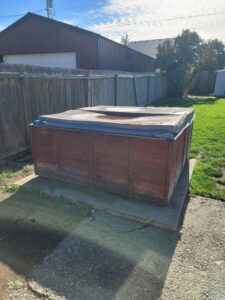 An old hot tub in a backyard, ready for removal by Primetime Hauling and Junk Removal in Spokane, WA.