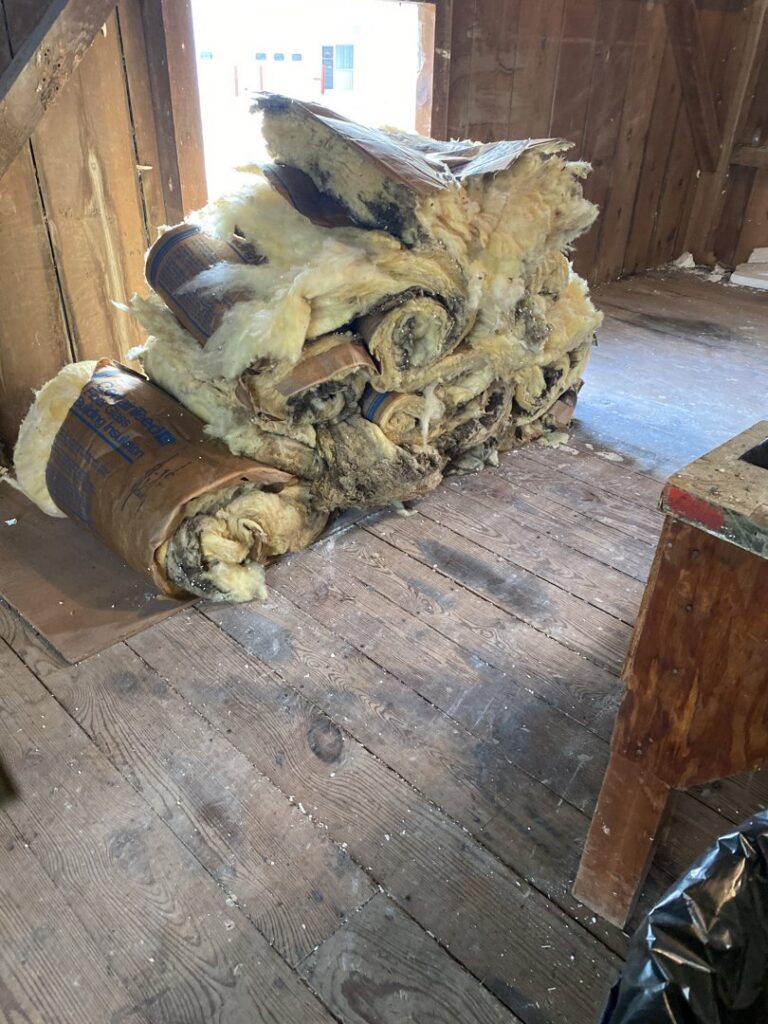 Rolls of old, possibly moldy, insulation ready for removal by KJ Haul Away Junk Removal in Cedar Rapids, IA.