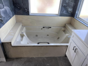 An old jetted tub in a bathroom before a complete renovation by Immaculate Refinishing in Arlington, TX.