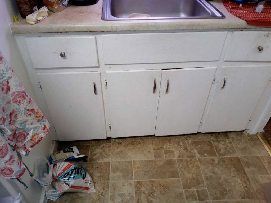 Old kitchen cabinets and sink before renovation by Vermont Professional Solutions LLC in South Burlington, VT.