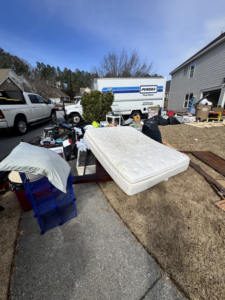 An old mattress and various household clutter piled in a front yard for removal by Eagle Junk Removal in Cloverdale, CA.