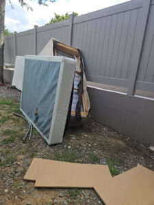 An old mattress and box spring discarded in a backyard, ready for removal by The Removal Squad LLC in Orlando, FL.