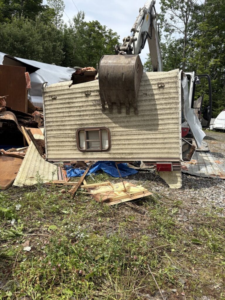 An old, long mobile home or trailer awaiting removal, a typical job for Tiny's Trash & Hauling Service L.L.C in Williamstown, VT