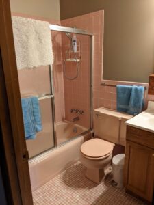 An outdated pink tiled bathroom, showing a before shot of a remodel project by Better Than Your Last Handyman in St. Charles, MO.