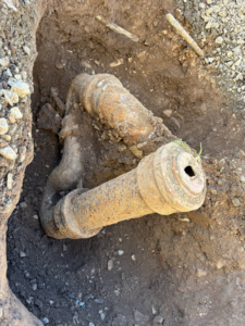 Old, rusty plumbing pipes exposed in a trench during a replacement project by Get it-Got It-Gone, LLC. in Goodview, VA.