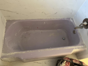 An old, dirty purple bathtub before refinishing by Immaculate Refinishing in Arlington, TX.