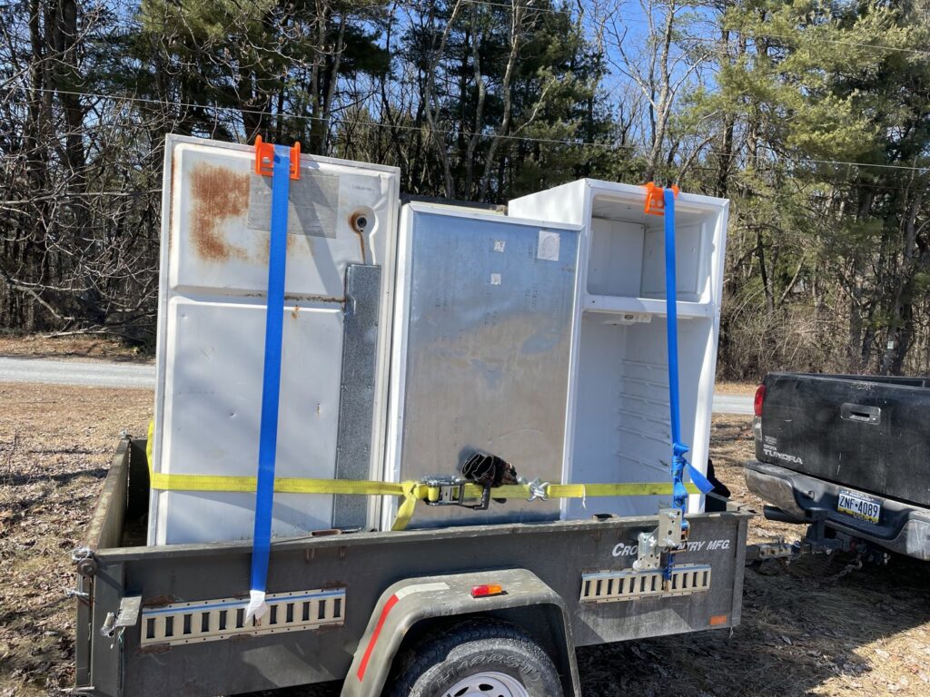 A trailer loaded with two old refrigerators for removal by Nu Earth Hauling and Recycling, offering appliance junk removal in Allentown, PA.