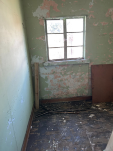 An old room with peeling paint and debris on the floor, requiring junk removal in Saint Albans, WV.