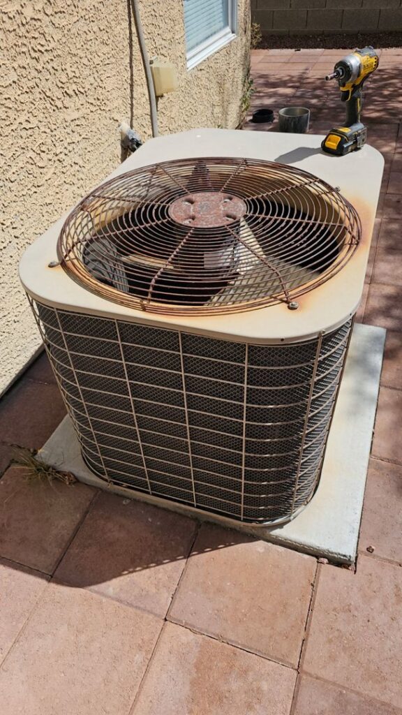 An old and rusty outdoor AC unit being inspected by Medina's Handyman LLC in Las Vegas, NV