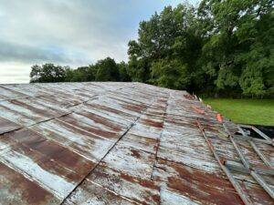 An old, rusty metal roof showing signs of wear, indicating a need for repair or replacement by Roofing Experts Care in Charlotte, NC.