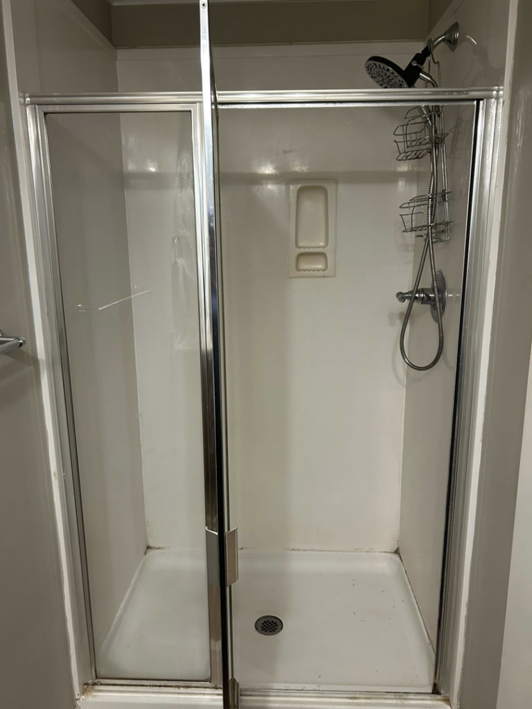An old, outdated shower stall before renovation, a service offered by Ingram Painting and Renovation in Birmingham, AL.