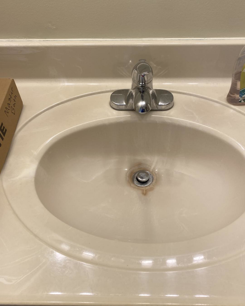 An old, stained bathroom sink with a chrome faucet, indicating a need for repair or replacement services from Tupelo Handyman in Tupelo, MS.