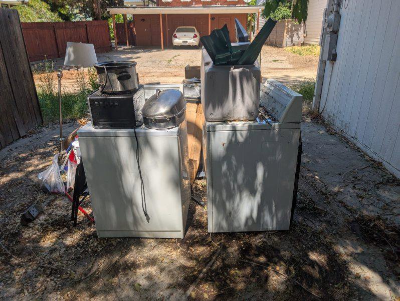 Old washing machines and other household items placed outside for Junk Holler to remove in Boise, ID.