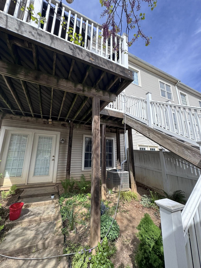 An old, weathered wooden deck and stairs in need of repair, a service offered by Pilgrim Decks and Fence LLC in Elkridge, MD.