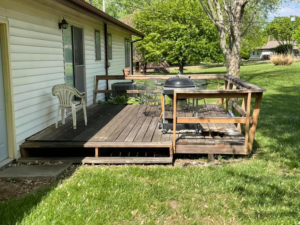 An old, weathered wooden deck before renovation by Capital T's Home Specialty LLC in Topeka, KS.