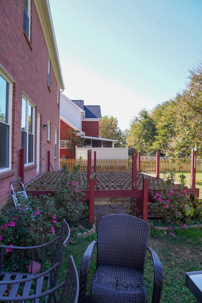 An old wooden deck in a backyard, showing a project before renovation by Vision Construction in Framingham, MA.