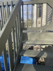Old wooden deck stairs with a blue tarp underneath, showing renovation work by Horstman Construction in Erie, PA.