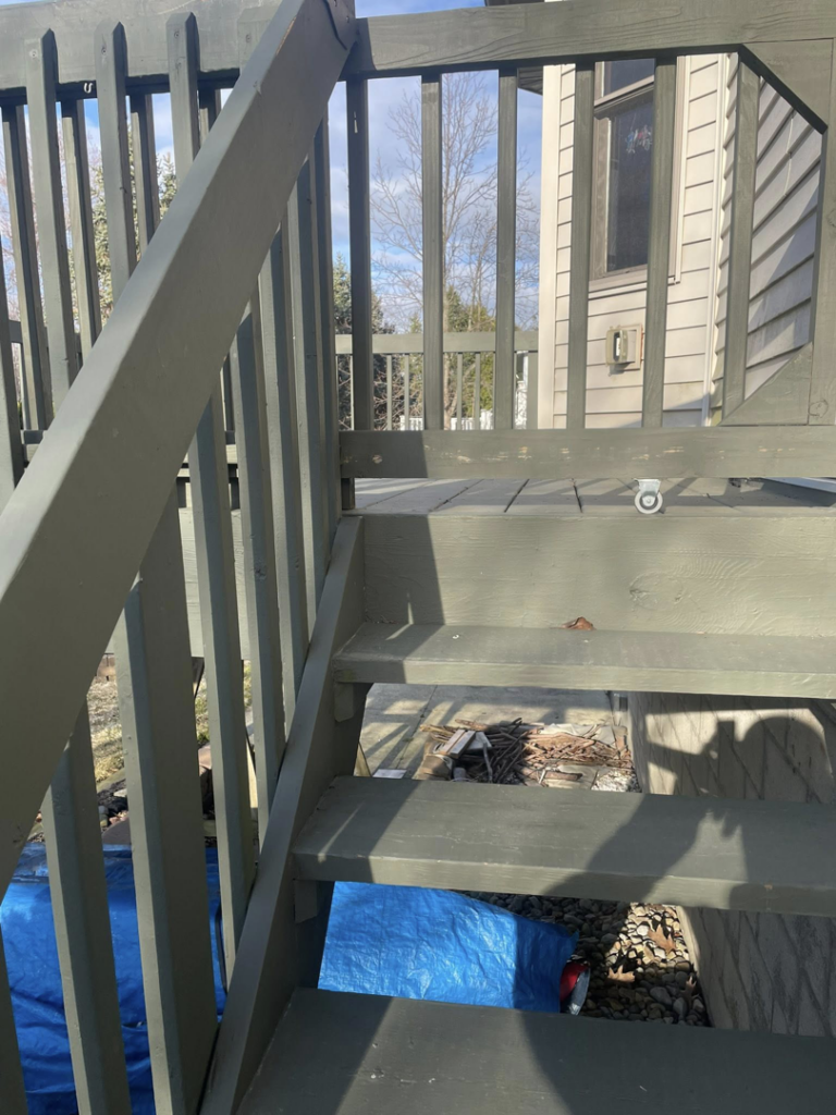 Old wooden deck stairs with a blue tarp underneath, showing renovation work by Horstman Construction in Erie, PA.