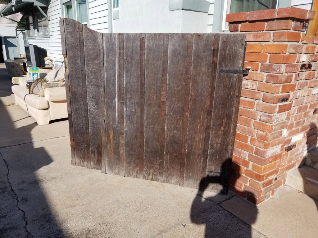An old wooden gate before replacement, showing the need for handyman services from Barry's Handyman Service in San Diego, CA.