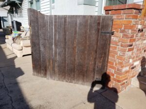 An old wooden gate before replacement, showing the need for handyman services from Barry's Handyman Service in San Diego, CA.