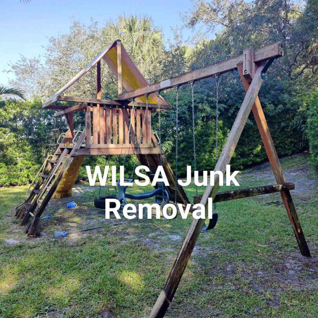 An old wooden playset in a backyard, ready for junk removal by Wilsa Junk Removal in Fort Lauderdale, FL.