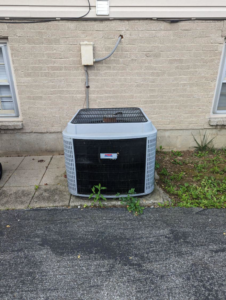 An older Rheem outdoor HVAC unit being serviced or replaced by Stivers HVAC in Lexington, KY.