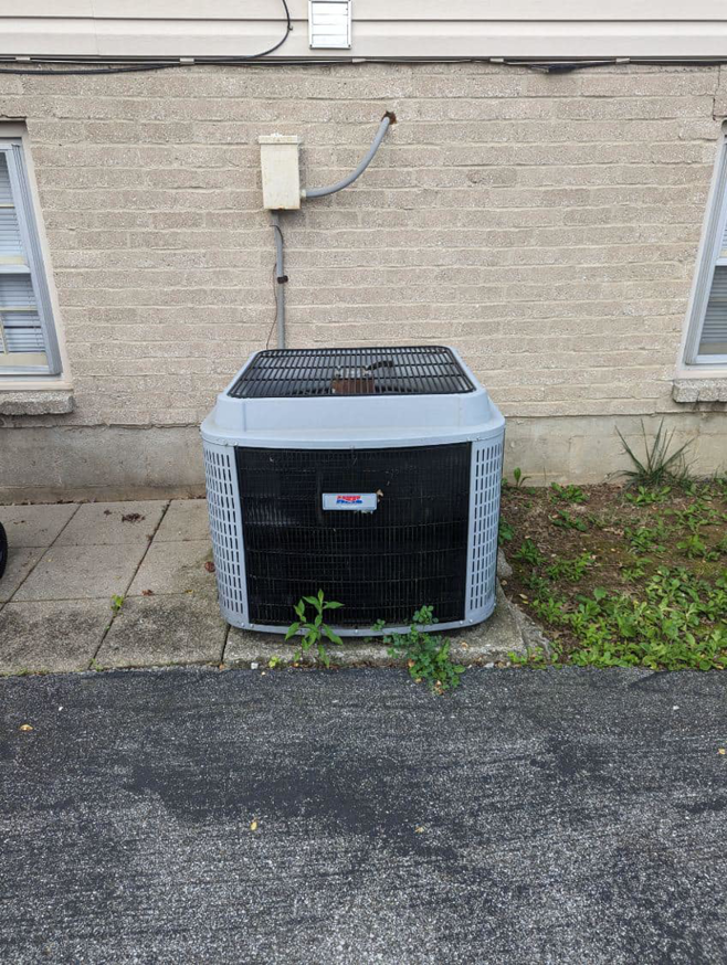 An older Rheem outdoor HVAC unit being serviced or replaced by Stivers HVAC in Lexington, KY.