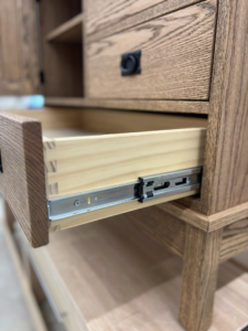 An open cabinet drawer with dovetail joints and a smooth slide, showcasing quality craftsmanship by Kingsbury Builders LLC in Janesville, WI