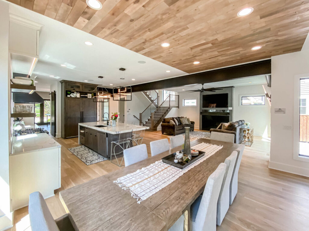 An open-concept dining and kitchen area with a unique wood plank ceiling and modern lighting by DJK Custom Homes in Naperville, IL