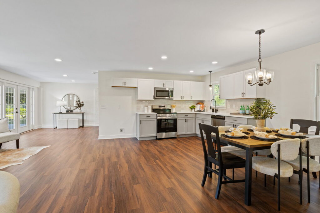An open-concept kitchen and dining area with new flooring by Heroic Builders LLC in Greenville, SC.