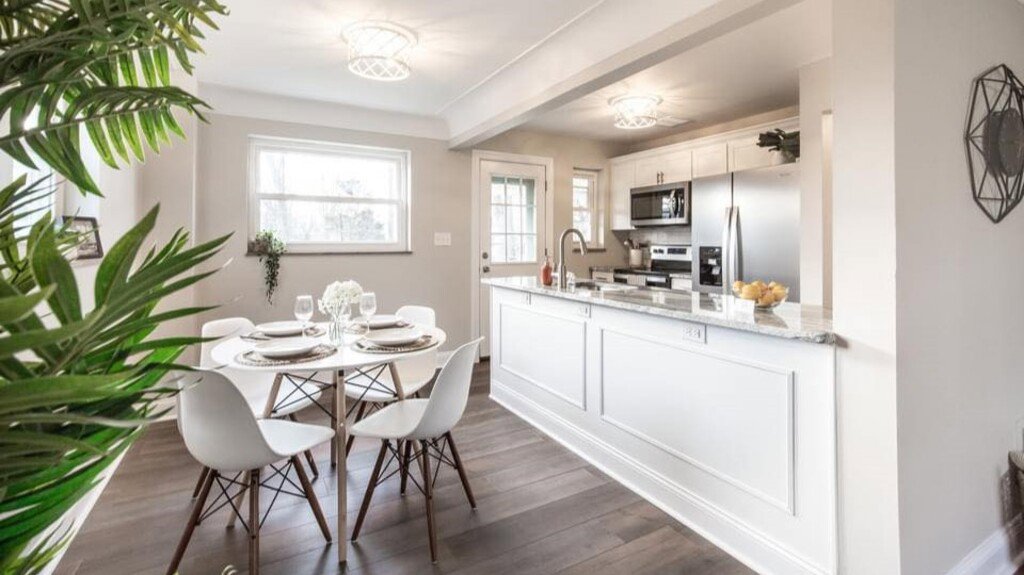 An open-concept kitchen and dining area renovation with new cabinets and flooring by Enjaycee Unlimited in Cincinnati, OH.