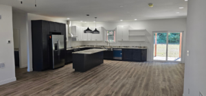 A wide view of a finished open-concept kitchen and living area with modern cabinetry by Susquehanna Valley Builders in Harrisburg, PA.