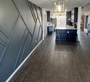 A beautifully remodeled open-concept kitchen and living area with new flooring and a decorative accent wall by Forged Builds Custom Remodels in El Paso, TX.