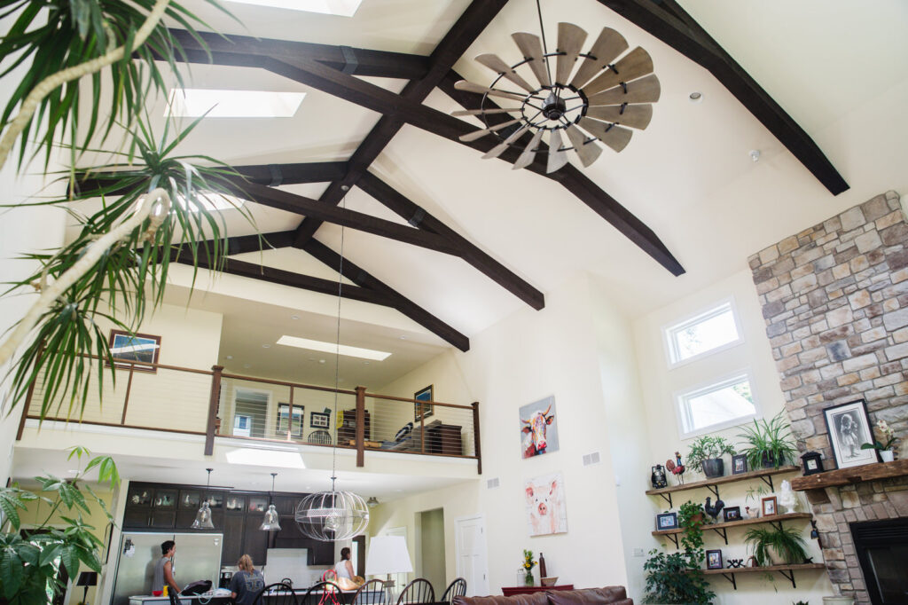 An expansive open-concept kitchen and living room with high ceilings and a stone fireplace by Corrado Custom Homes, Inc. in Kutztown, PA