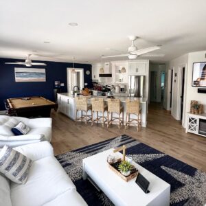 An open-concept living room and kitchen area with a blue accent wall and pool table, designed and built by Bob Build's WNY in Buffalo, NY.