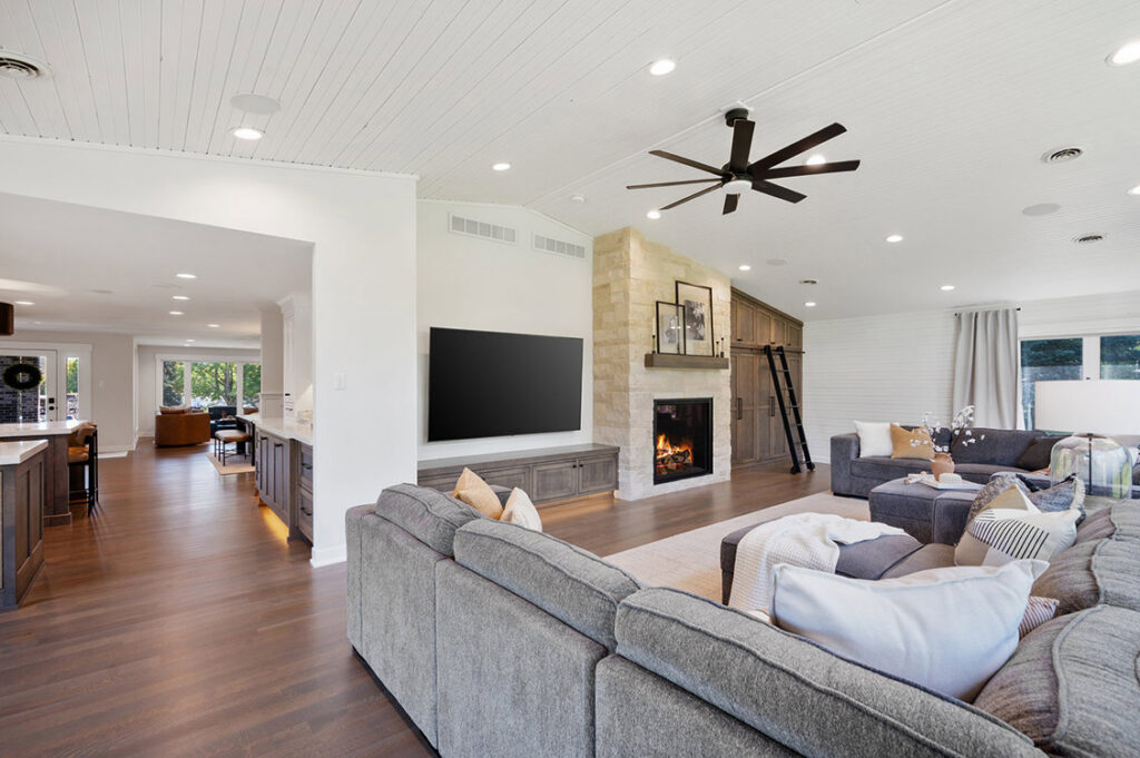 An open concept living room renovation with a stone fireplace and built-in shelving by J Brothers Design- Build- Remodel, Inc. in Corcoran, MN