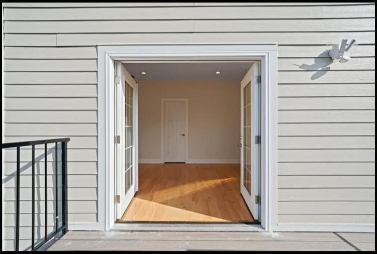 Open French doors connecting a newly built deck to a renovated interior room by Revival Home Remodeling in Chicago, IL.